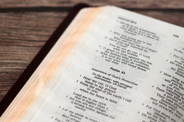 Assurance of God's protection, psalm 61 in open holy bible book on wooden table. Christian...