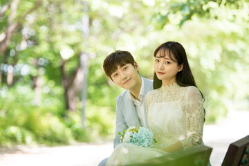 A loving couple is taking wedding photos outdoors for their wedding.