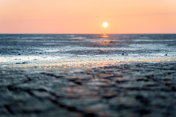 Mud flat of the 'waddenzee' during low tide under scenic Sundown sky, The Netherlands