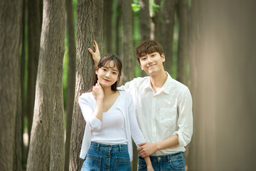 Fototapeta premium A lovely young couple are having fun in a forested park.