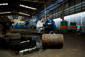 Fototapeta na wymiar Tanks of dangerous chemicals in factories. Teams of workers in protective suits and gas masks handle hazardous chemicals. Find ways to prevent it from causing harm to the factory.