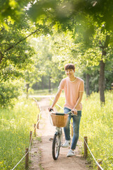 A young man is riding a bicycle in the park.