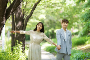 A loving couple is taking wedding photos outdoors for their wedding.