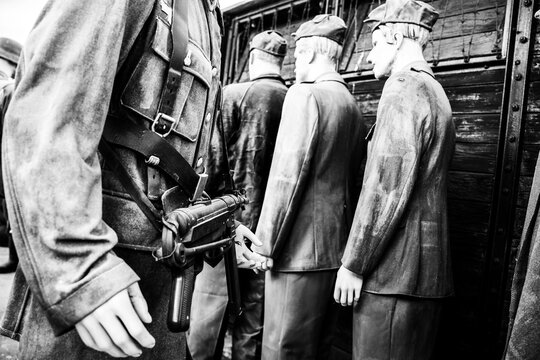 Close-up of german soldier with rifle in hand during deportation of jews in wwii period - Concept of shoah, holocaust and deportation of jewish people - Museo Piana delle delle Orme, Latina, Italy
