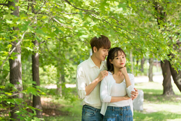 Fototapeta premium A lovely young couple are having fun in a forested park.
