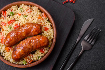 Delicious chicken or pork sausages baked on the grill with porridge and vegetables