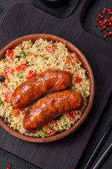 Delicious chicken or pork sausages baked on the grill with porridge and vegetables