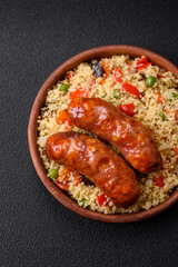 Delicious chicken or pork sausages baked on the grill with porridge and vegetables