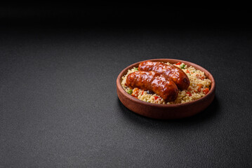 Delicious chicken or pork sausages baked on the grill with porridge and vegetables