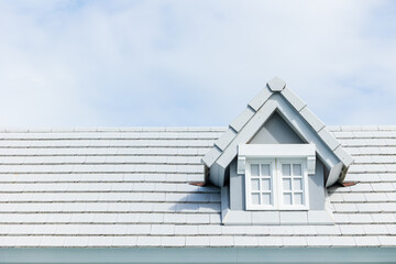 Garret room at shingles roof modern asphalt material roof tiles on top of home on summer clear blue sunny sky background