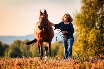 Horse is led by a woman over heather, woman smiles and strokes her horse..