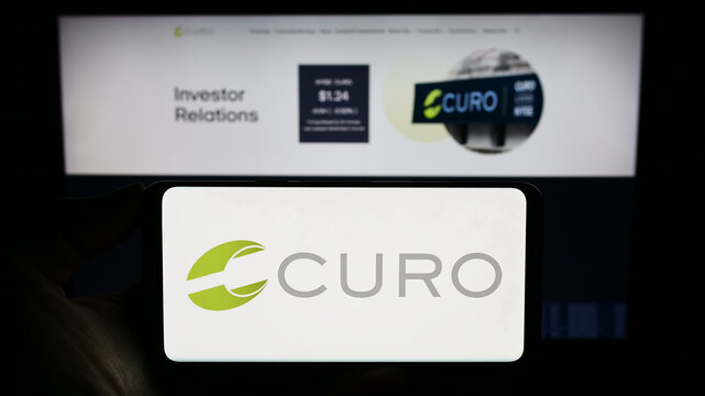 Stuttgart, Germany - 09-05-2023: Person holding smartphone with logo of US financial company CURO Group Holdings Corp. on screen in front of website. Focus on phone display.
