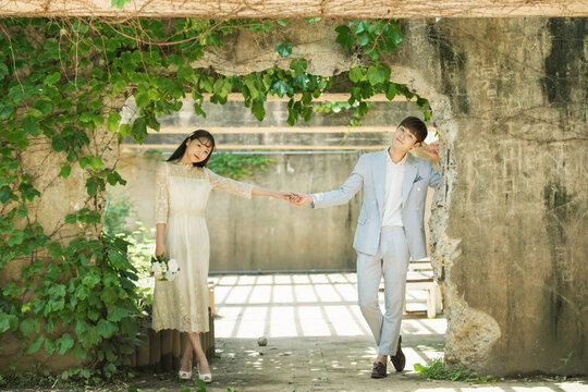 A loving couple is taking wedding photos outdoors for their wedding.	