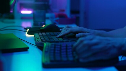 Close-up hands of unrecognizable gamer male typing on keyboard, playing video game. Male hands pushing buttons on computer keyboard. Programmer or hacker working in networks, cyberspace, slow motion.