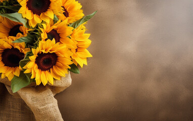 A bouquet of sunflowers displayed against a textured burlap backdrop with large space for text