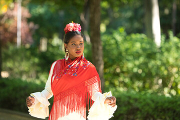 Young black woman dressed as a flamenco dancer stands in a famous park next to a duck pond in...