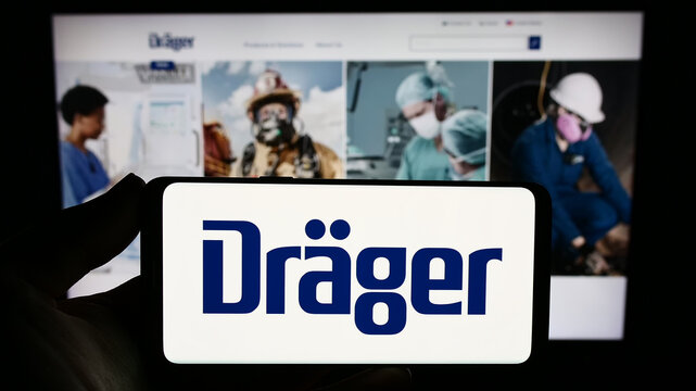 Stuttgart, Germany - 09-09-2023: Person holding smartphone with logo of German company Dr&auml;gerwerk AG Co. KGaA (Dr&auml;ger) on screen in front of website. Focus on phone display.