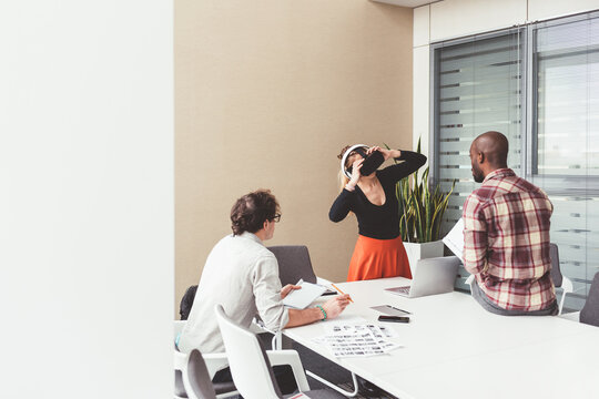 Three millennials multiethnic businesspeople using 3D viewer