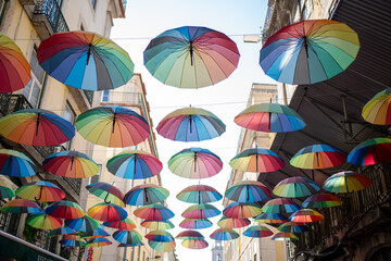 Fototapeta na wymiar Pride month. Rainbow umbrellas on blue sky background. Many colorful umbrellas, street decoration for festivals. Concept Diversity 