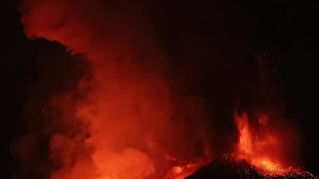 Etna volcano timelapse during eruption at night with intense lava explosion and smoke