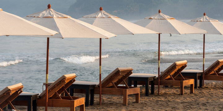 Beach Chairs And White Umbrellas Lined Up On The Beach Along The Ocean; Sayulita, Mexico