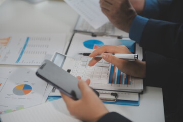 Financial analysts analyze business financial reports on a digital tablet planning investment project during a discussion at a meeting of corporate showing the results of their successful teamwork.