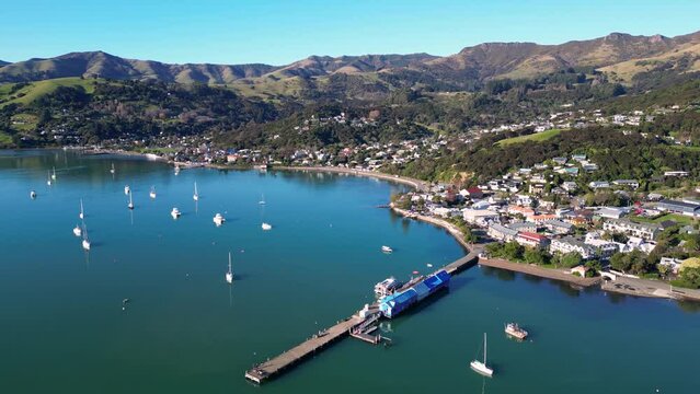Akaroa, New Zealand: Aerial drone footage of the stunning Akaroa idyllic village in the Banks Peninsula in the Christchurch region of Canter bury in New Zealand south island on a sunny day. 
