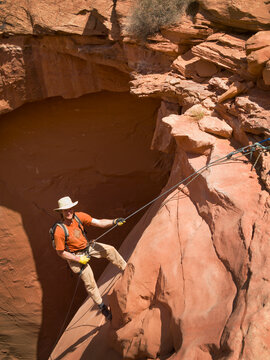 Man rappelling into a canyon; San rafael swell utah united states of america