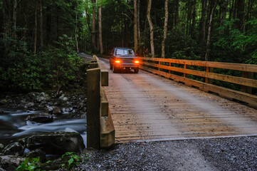 A vehicle going over a river on a wooden bridge in great smoky mountains national park; Tennessee united states of america