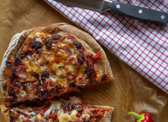 Tex mex pizza with kidney beans, bacon, cheddar cheese, tomatoes and onions