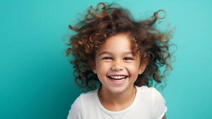 studio photo of a laughing girl on a turquoise background