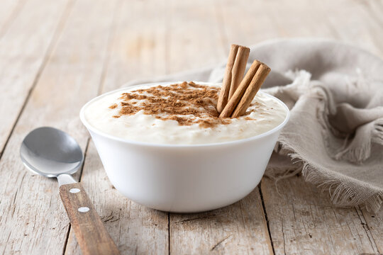 Arroz con leche. Rice pudding with cinnamon in bowl on wooden table