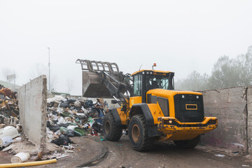 Heavy construction machine, front end loader moving along recycling center area, close up view....