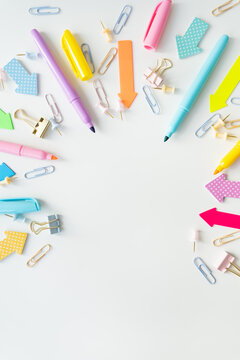 Top view of bright school supplies with blank paper for layout or text. Vertical photo.