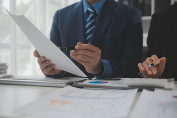 Obraz premium Financial analysts analyze business financial reports on a digital tablet planning investment project during a discussion at a meeting of corporate showing the results of their successful teamwork.