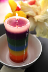 Candle of the color of the 7 chakras with fresh flowers