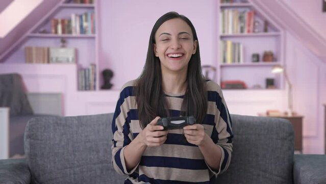 Excited Indian girl gamer playing video games