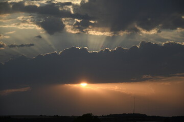 Cielo al atardecer en un día de verano con nubes y rayos solares