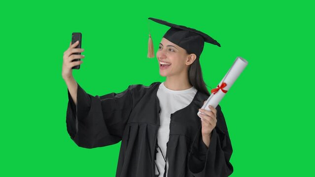Happy Indian college graduate girl clicking selfies Green screen