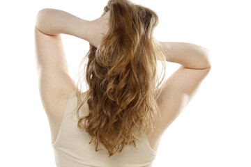 Back,  rear view of a young blond woman tying her long hair on a white background