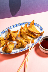 Fried wontons with soya sauce on a vibrant colorful background - 647763704