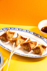 Fried wontons with soya sauce on a vibrant colorful background - 647763757