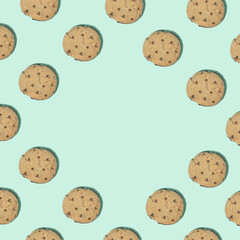 Pattern made of chocolate chip cookies on bright green background. Minimal food concept with copy space.