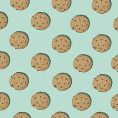 Pattern made of chocolate chip cookies on bright green background. Minimal food concept. Flat lay.