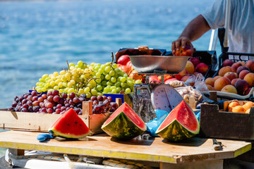 Watermelons, green and purple grapes, peaches in a boat in Croatia