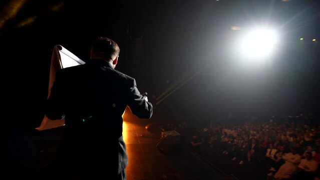 conference of trendy psychologist, business speaker or life coach on stage, man drawing on sheet