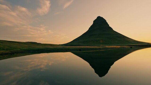 Sunrise over volcanic Kirkjufell mountain and lake reflection in summer at Iceland