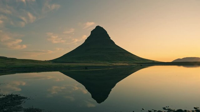 Sunrise over volcanic Kirkjufell mountain and lake reflection in summer at Iceland