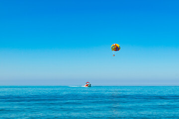 parasailing. ride on a colored parachute attached to a motor boat. place for text