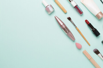 Flat lay with makeup products and tools on color background
